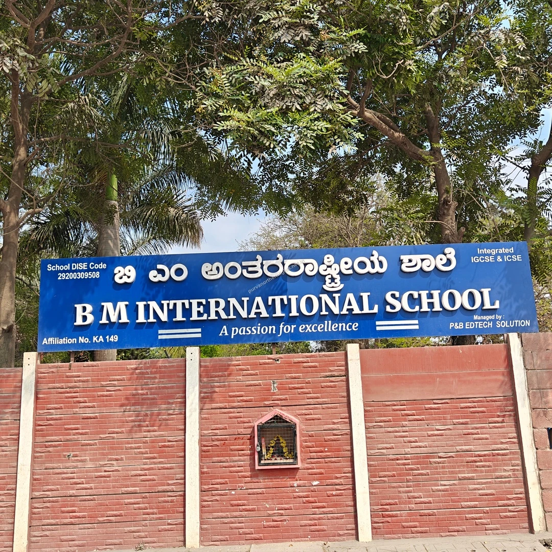 BM Institute Entrance Another perspective of the BM International School boundary wall and sign under the shade of large green trees.