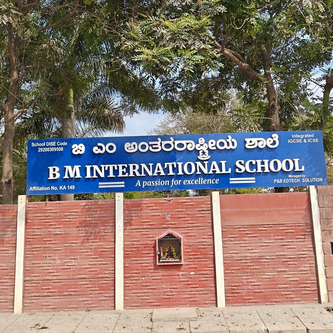 BM School Sign The bright blue signboard of BM International School mounted on a red brick wall, captured during a sunny walk on Mar 13.