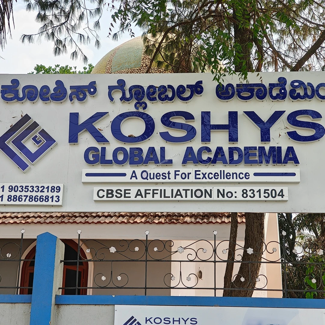 Koshys Entrance Board The prominent bilingual entrance board of Koshys Global Academia framed by a dome structure and trees, taken on a walk this Mar 13.