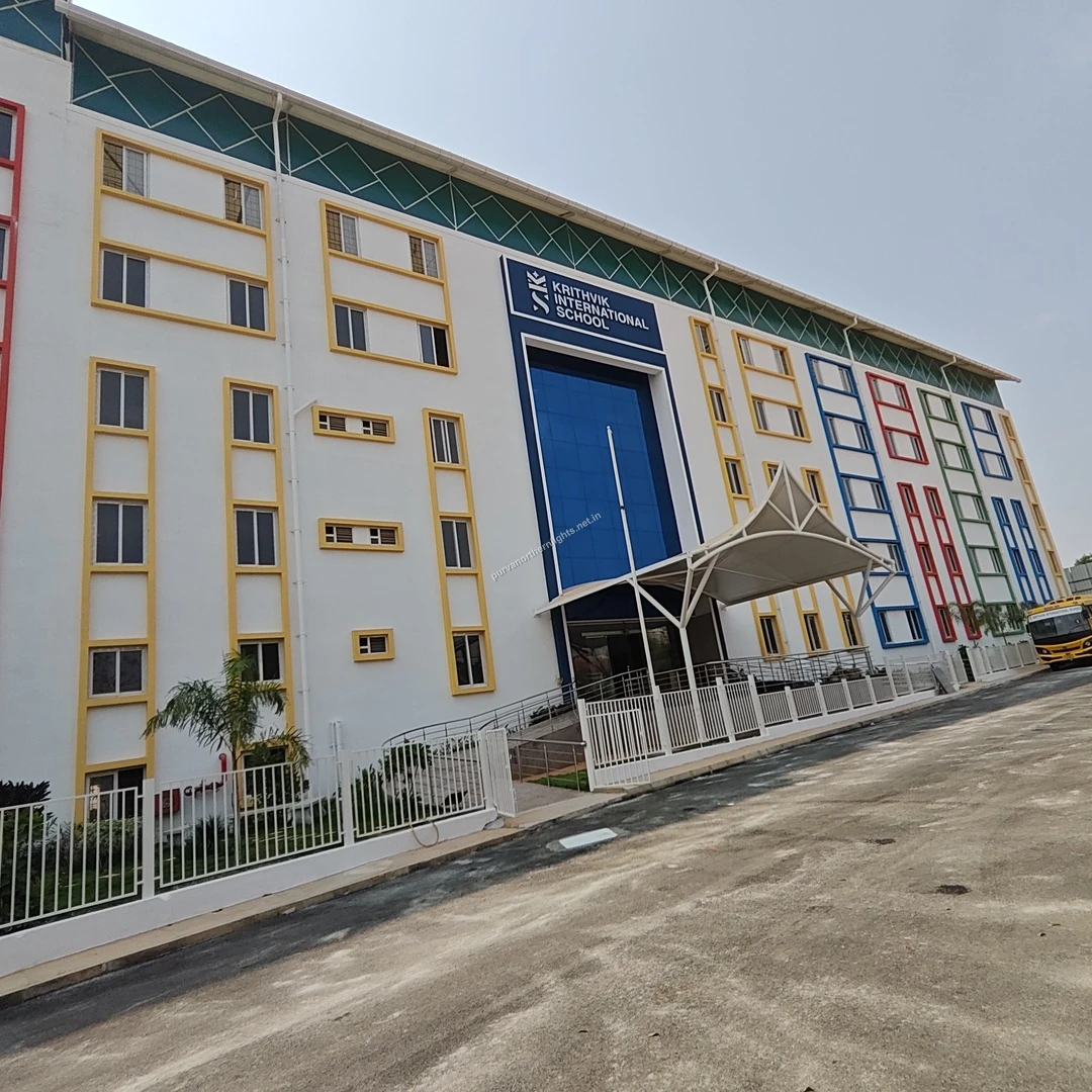 Krithvik Street Perspective A street-level perspective of the sprawling Krithvik International School campus with a yellow school bus parked outside, taken on a sunny Mar 13.