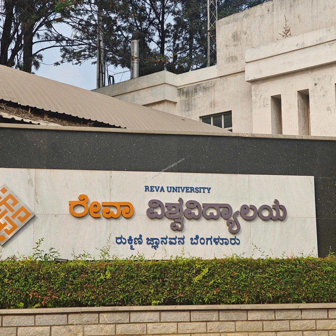 REVA Kannada Sign The striking regional language signage for REVA University mounted on a sleek modern wall with green landscaping.