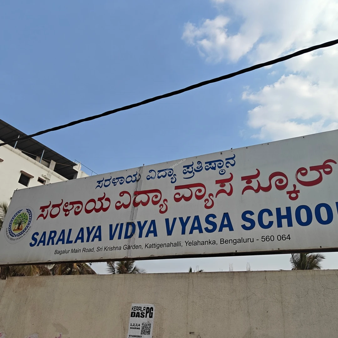 Saralaya Bilingual Board A clear daytime perspective of the Saralaya Vidya Vyasa School name board showing its bilingual typography and local address details.