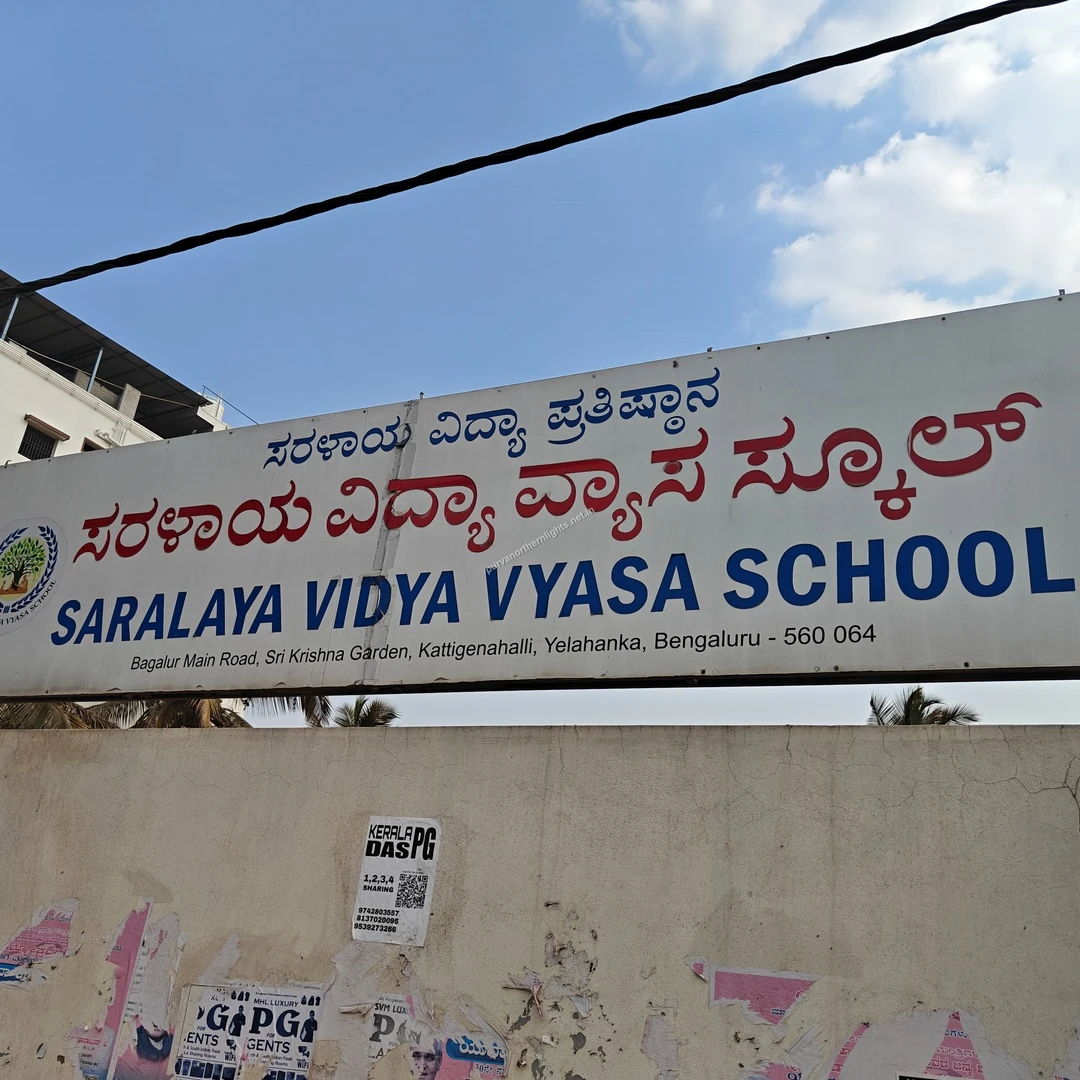 Saralaya Billboard Display A close-up view of the Saralaya Vidya Vyasa School billboard featuring red and blue text, located conveniently near Purva Northern Lights.