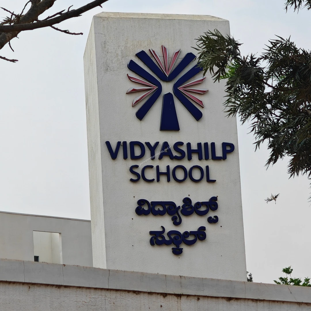 Vidyashilp Front Pillar The sturdy concrete signpost marking the entrance to Vidyashilp School, showing its English and Kannada inscriptions clearly.
